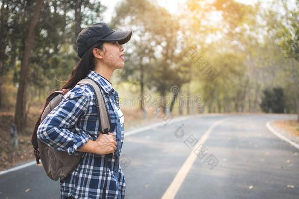 幸福的亚洲人女人背包采用指已提到的人路和森林背景,关于