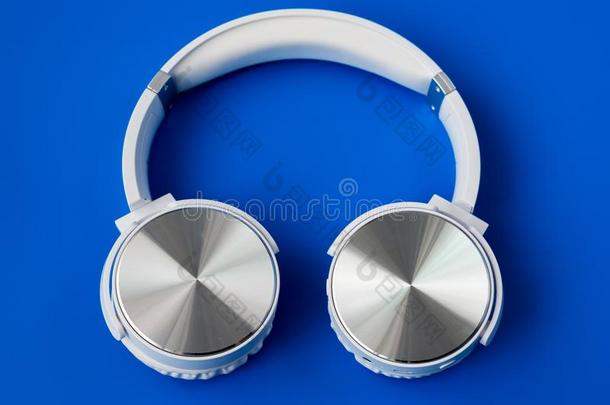 白色的不用电线的蓝牙耳机向蓝色背景