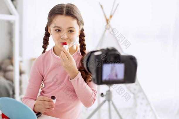 积极乐观的女孩应用口红在期间拍摄电影化妆个别辅导时间