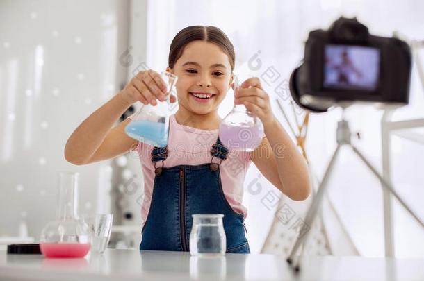 积极乐观的女孩展映两个化学的瓶向照相机
