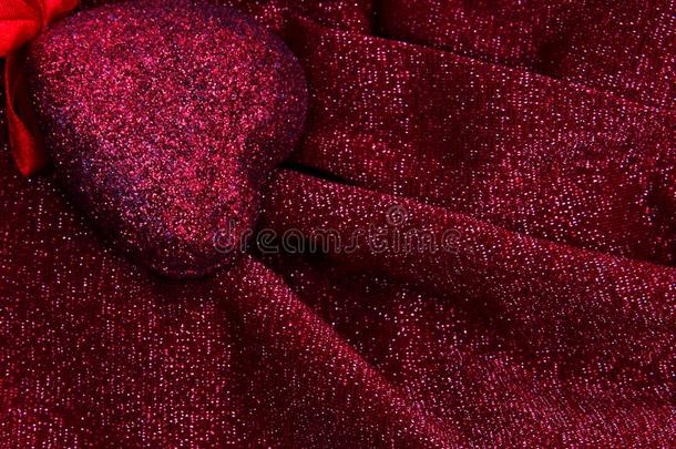红色的心向光滑的优美的红色的和银色的织物奢侈布