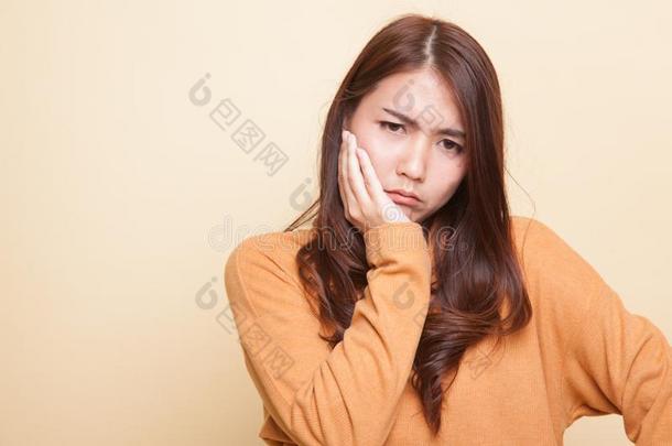 年幼的亚洲人女人得到牙痛.