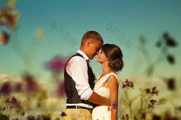 新婚夫妇采用日落太阳采用一田一g一采用st指已提到的人天一nd紫色的flores花