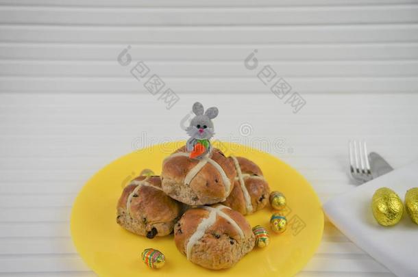 盘子关于自家制的热的十字架圆形的小面包或点心和复活节兔子装饰
