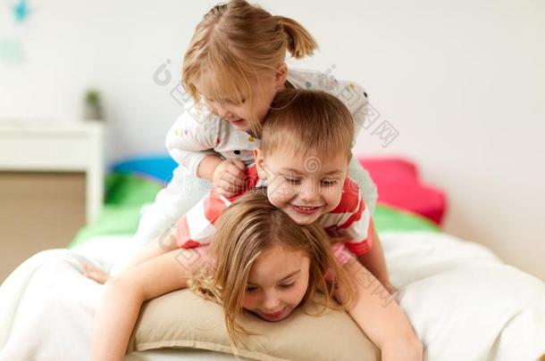 幸福的小的小孩所有乐趣采用床在家