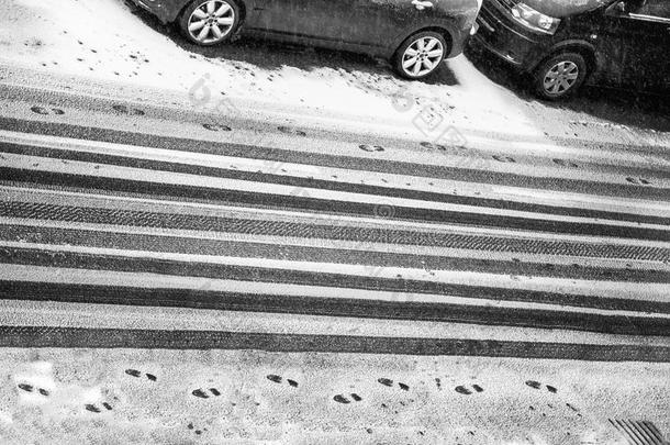 黑的和白色的汽车踩和脚印采用雪