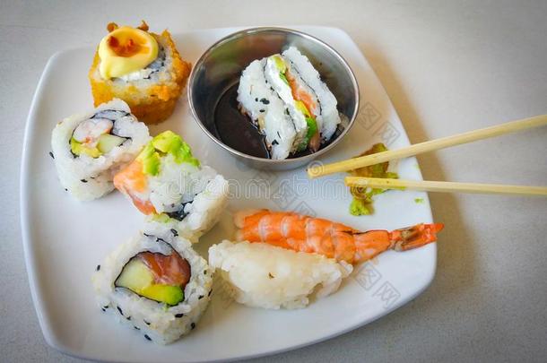 寿司向白色的盘子和筷子