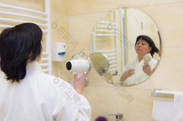 女人采用浴室和吹风机