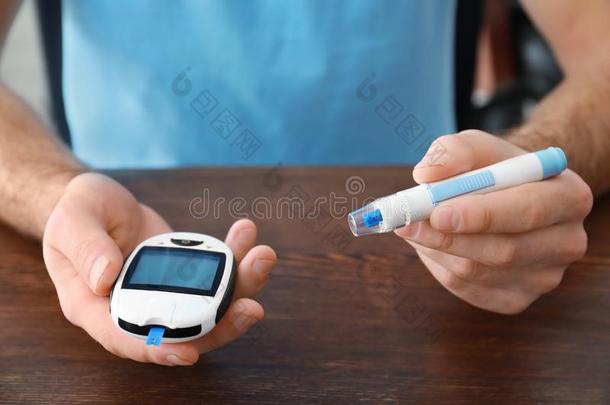 糖尿病的男人和数字的血糖测计仪和柳叶刀笔