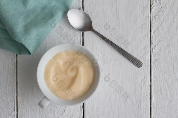 酸奶采用杯子向白色的乡村的木制的表背景和木材体积单位