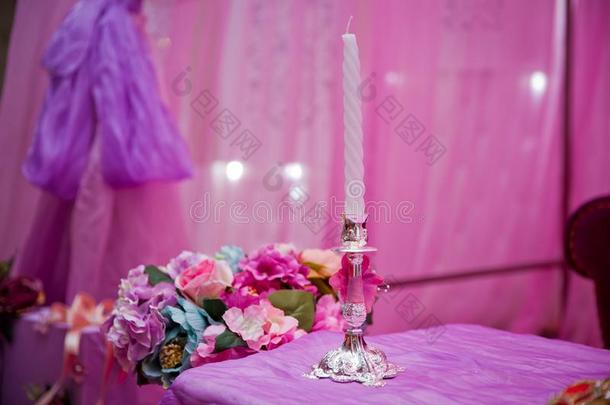 白色的装饰的蜡烛粉红色的背景.美丽的蜡烛向