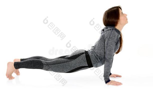 年幼的女人做瑜伽瑜珈的任何一种姿势眼镜蛇使摆姿势Bhujang瑜珈的任何一种姿势
