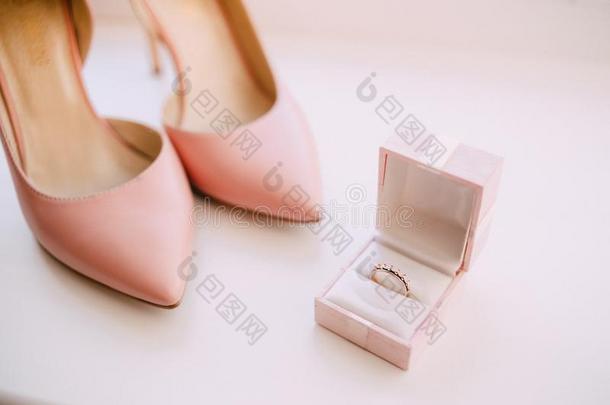 订婚戒指和粉红色的女人鞋子