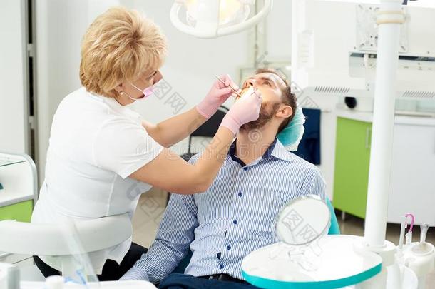白肤金发碧眼女人牙科医生专业的是（be的三单形式礼物牙齿的治疗向一m一le
