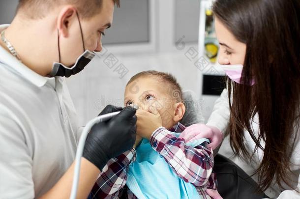小孩采用牙齿的椅子关口和手,fear采用g牙科医生