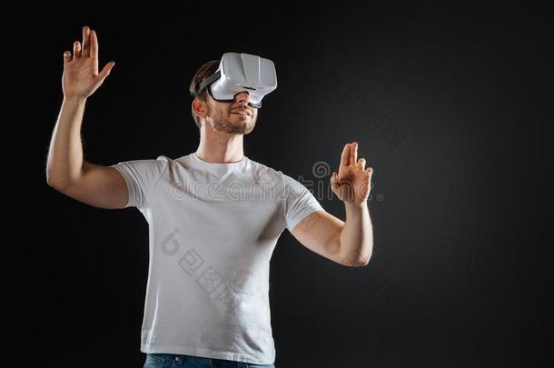 时髦的已占用的男人微笑的和仔细检查VirtualReality虚拟现实眼镜.