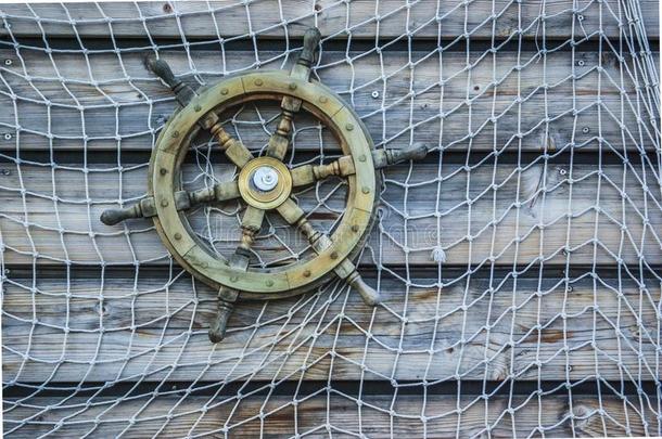 怀旧的船木制的转向装置轮子和捕鱼网附<strong>加</strong>的英语字母表的第20个字母