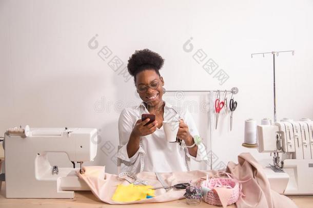 笑的女裁缝缝纫采用工作室