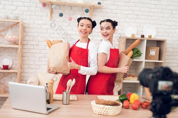两个厨房的博客拿住在上面包装袋和食物向照相机.