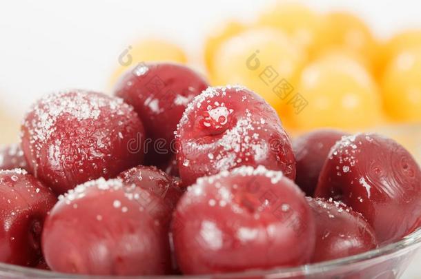 红色的和黄色的樱桃煮熟的糖渍水果和食糖