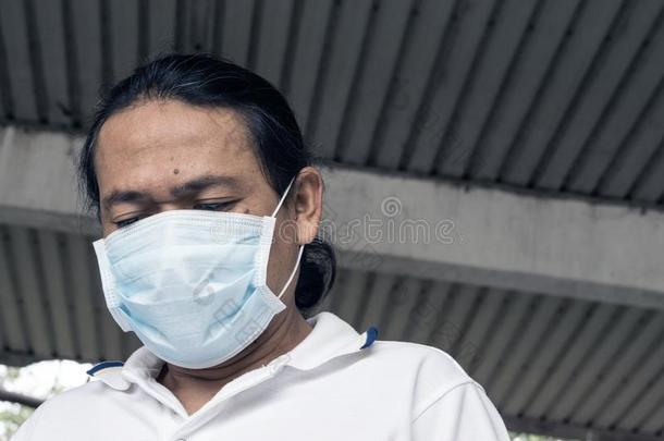 亚洲人男人穿着面容面具医学的保护采用木材工厂.