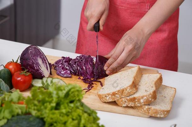 手锋利的紫色的甘蓝向板采用厨房房间