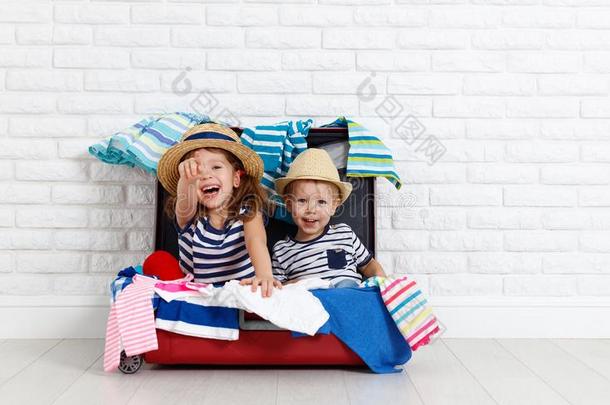 幸福的笑的孩子们和手提箱出行向一旅游