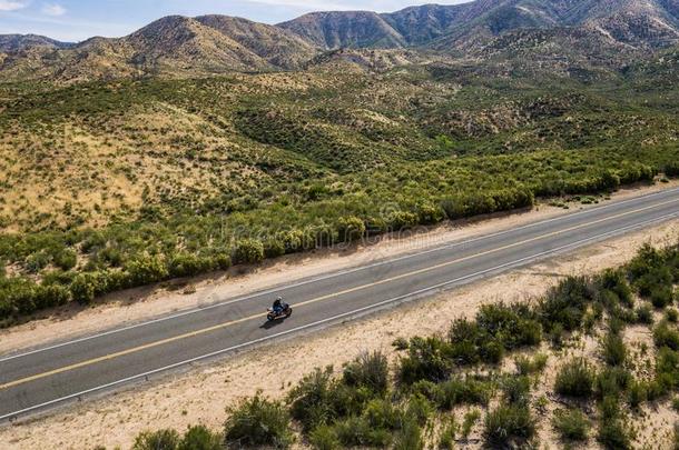 孤单的骑摩托车的人向沙漠公路