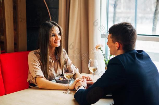 年幼的幸福的对浪漫的日期喝玻璃关于白色的葡萄酒在关于