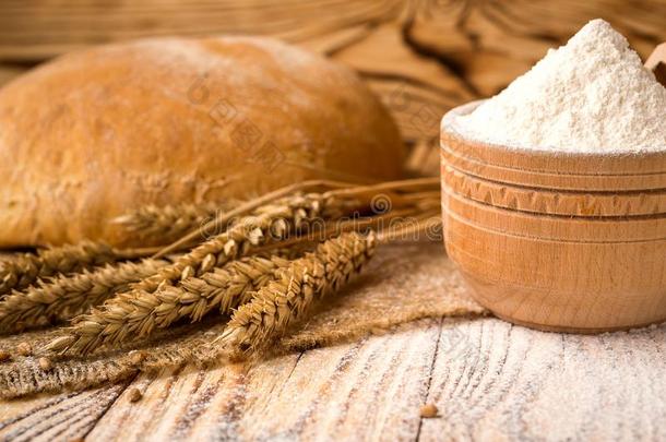 面包和小麦面<strong>粉</strong>,穗和双齿鱼叉向木制的表.agriculture农业