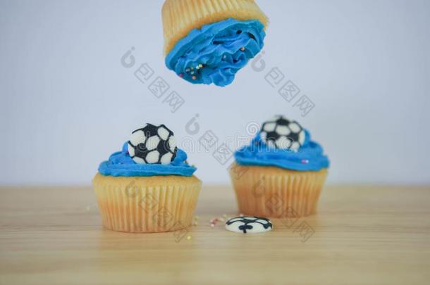 蓝色冰冷的杯子蛋糕和袖珍型的东西足球装饰