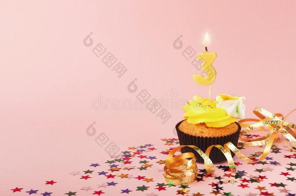 第三生日纸杯蛋糕和蜡烛和少量