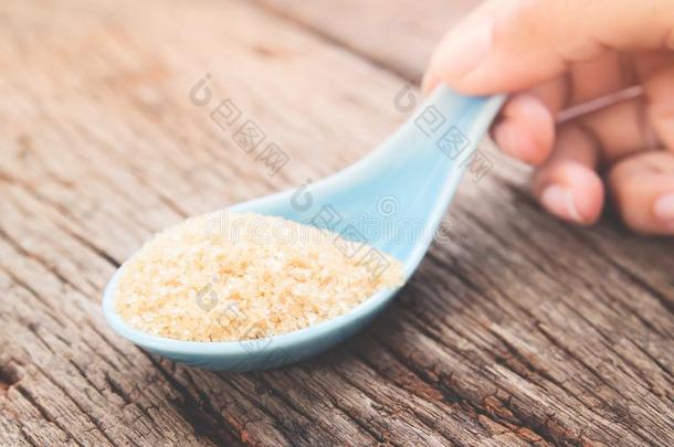 女人手佃户租种的土地勺和棕色的食糖,不健康的和日常饮食Colombia哥伦比亚