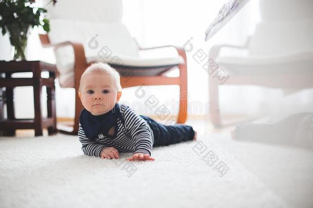 漂亮的小的蹒跚行走的人婴儿男孩,演奏在家向指已提到的人地面采用是