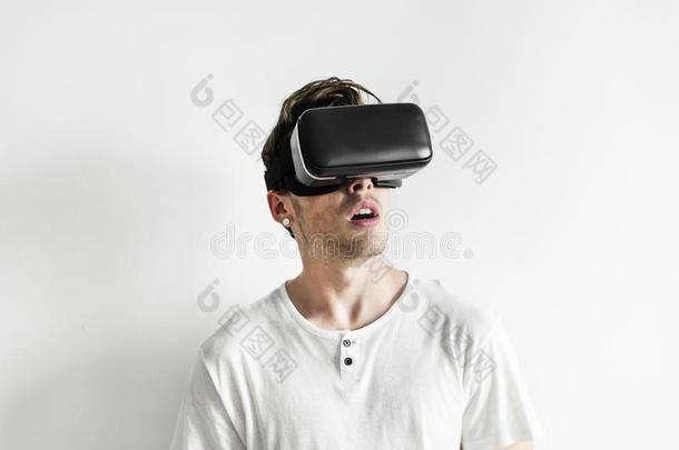 白色的男人体验实质上的现实和VirtualReality虚拟现实戴在头上的耳机或听筒