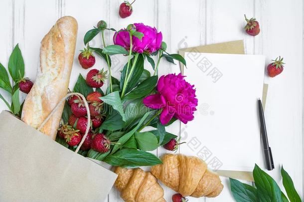 纸购物袋和新鲜的面包,羊角面包,草莓,英语字母表的第16个字母