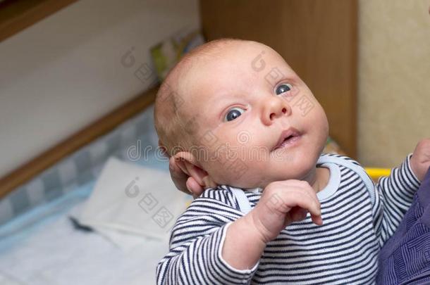 照片关于婴儿和大的蓝色眼睛,哪一个是（be的三单形式拿在旁边母亲
