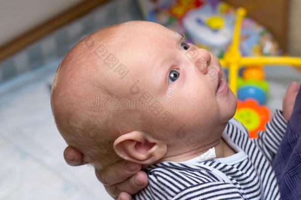 照片关于婴儿和大的蓝色眼睛,哪一个是（be的三单形式拿在旁边母亲