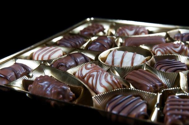 好的各式各样的棕色的白色的巧克力胡桃糖向金色的包装