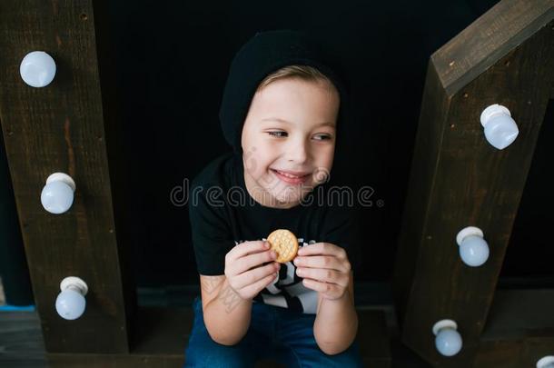 年幼的微笑的男孩吃饼干.特写镜头