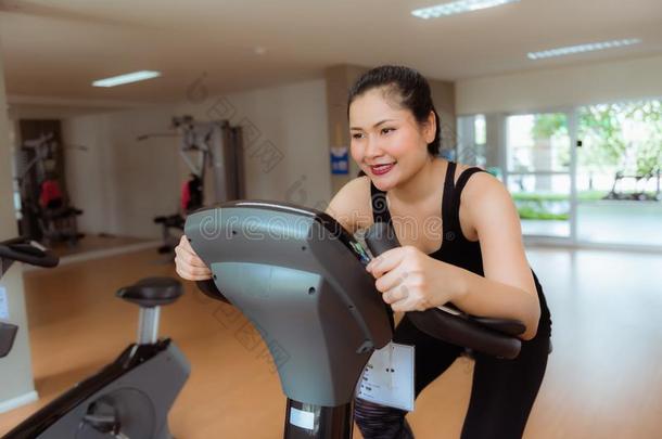 亚洲人女人锻炼向骑脚踏车兜<strong>风采</strong>用健康健身房,有关运动的和健康状况