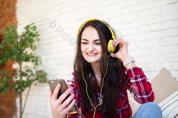 幸福的女孩收听的向音乐在线的从你的智能手机席廷