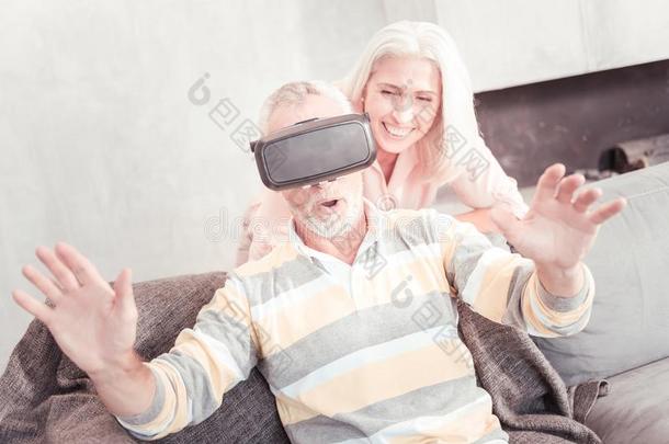 吃惊的<strong>坚定不移</strong>男人使用VirtualReality虚拟现实眼镜和一次向指已提到的人沙发.