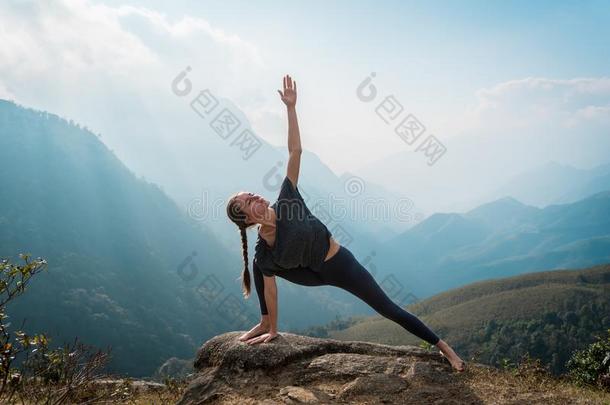 女人做瑜伽向山悬崖在日出.山神陆地