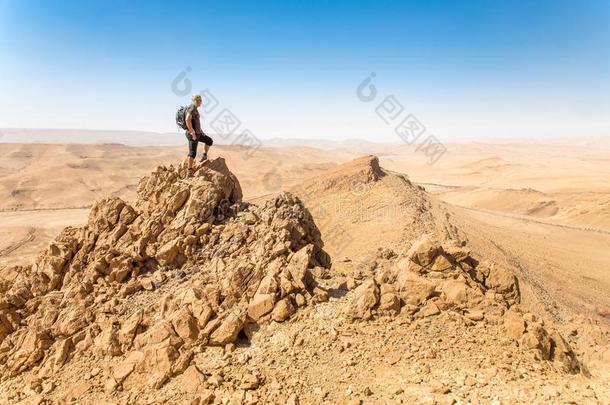 背着背包徒步旅行的人旅行者起立沙漠山悬崖背脊边锐气