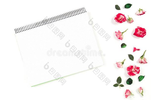 敞开的螺旋笔记簿和玫瑰框架.平的放置,顶看法