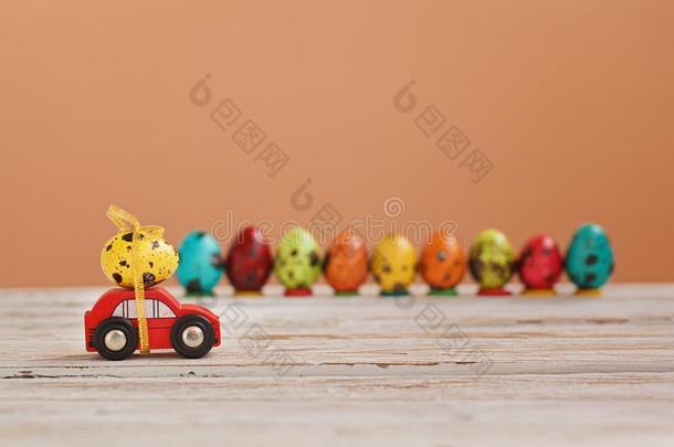 复活节假日观念-红色的玩具汽车汽车rying黄色的鸡蛋.