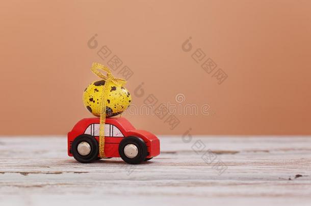 复活节假日观念-红色的玩具汽车汽车rying黄色的鸡蛋.