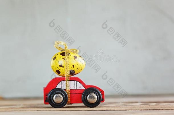 复活<strong>节</strong>假日观念-红色的玩具<strong>汽车汽车</strong>rying黄色的鸡蛋.