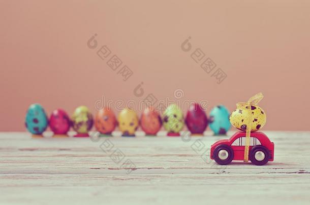 复活节假日观念-红色的玩具汽车汽车rying黄色的鸡蛋.某种语气的